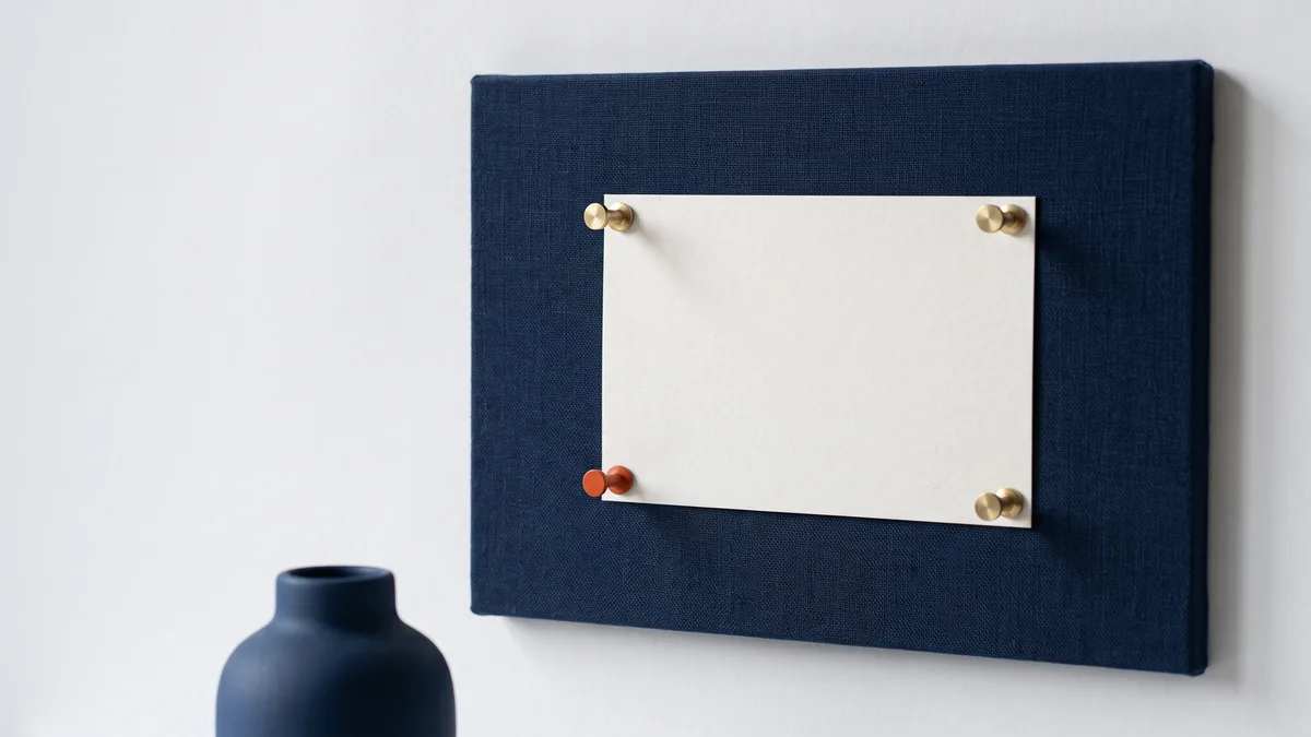 Four push pins holding a card to a pinboard, one pin orange, the cover image for 4 Things To Remember About AI Overviews & SEO