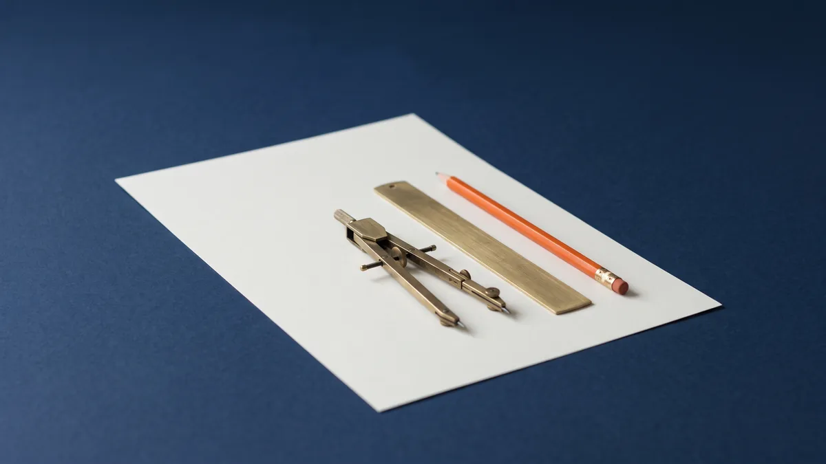 Drafting paper with a brass compass, a straightedge and an orange pencil, the cover image for 2025 On-Site SEO Best Practices for Optimizing Any Webpage