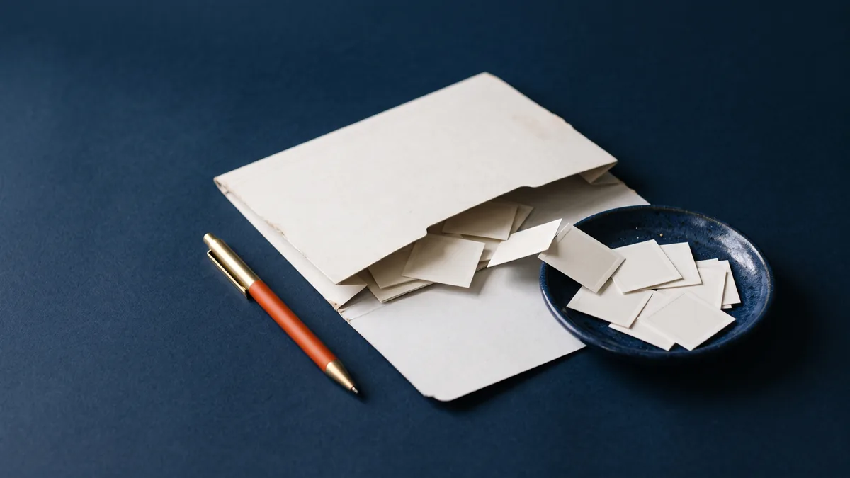 File folder of tiny blank photo prints being swept into a dish, the cover image for Deleting .thumbnail folder is OK!
