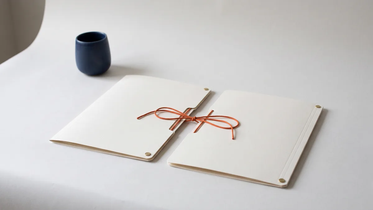 Two identical file folders linked by an orange string, the cover image for DropBox: Your answer to file backup and sharing (free invite)