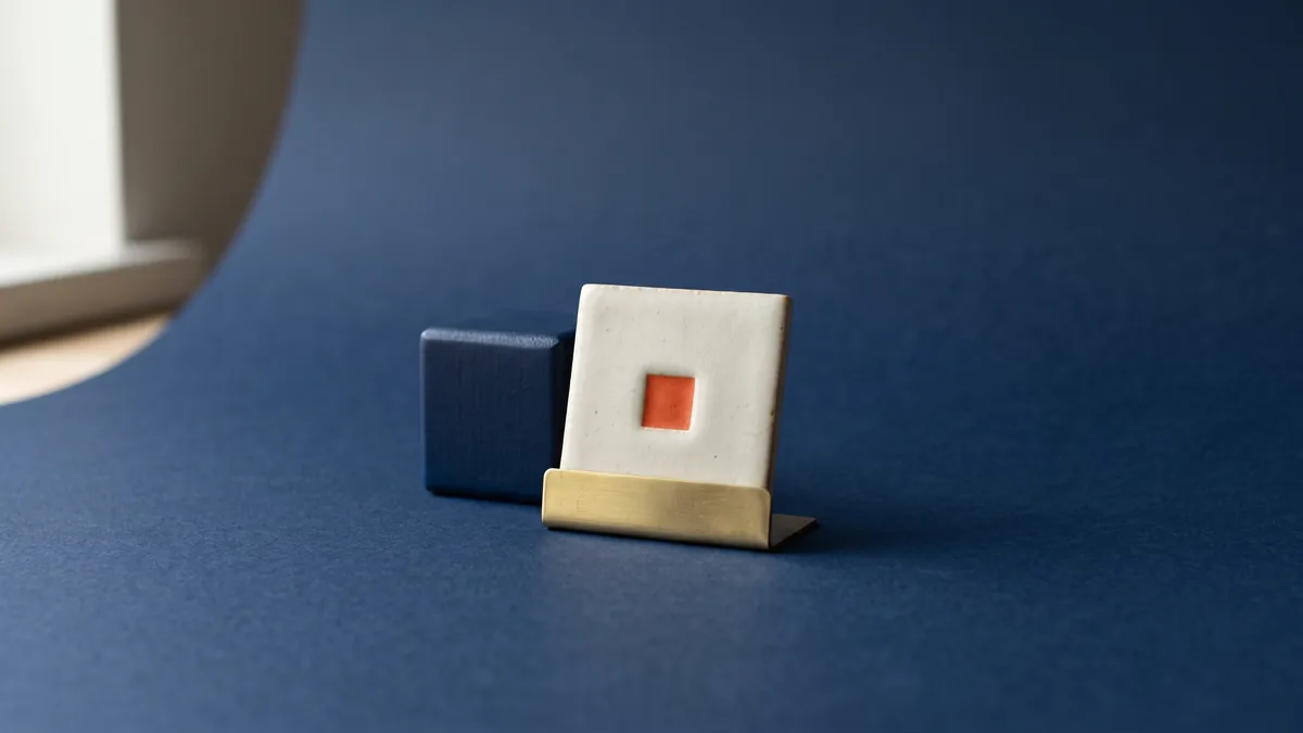 Tiny square tile with an orange inlay in a brass stand, the cover image for Favicon Generator Tool