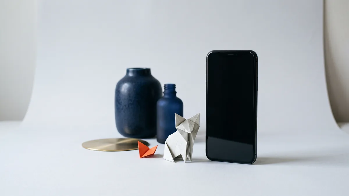 Smartphone standing upright beside an origami fox, the cover image for Fennec Coming Soon (Firefox Mobile)