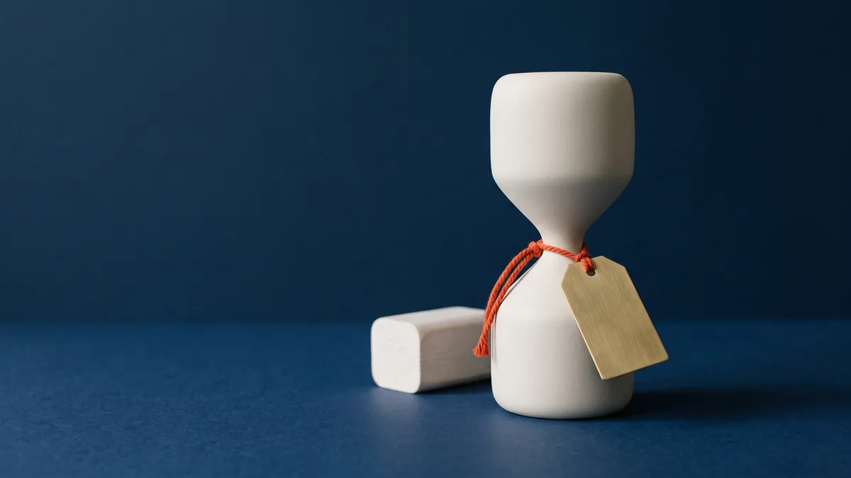 Brass price tag tied to an hourglass with orange string, the cover image for SEO Consultant Rates
