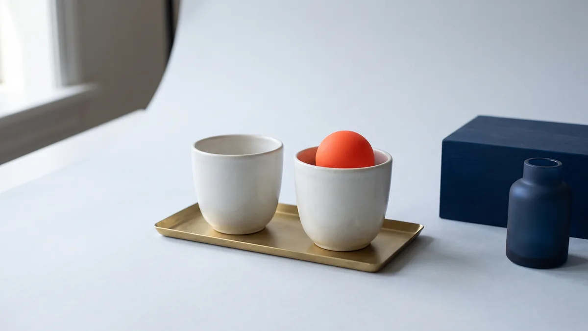 Two identical ceramic cups side by side, one holding an orange ball, the cover image for The Ultimate Guide to Conversion Rate Optimisation Best Practices