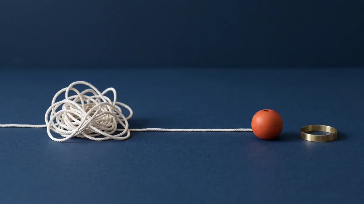Tangled string pulled into one straight line ending in an orange bead, the cover image for Fix Weird WordPress Characters: â€, â€œ, â€™, â€˜